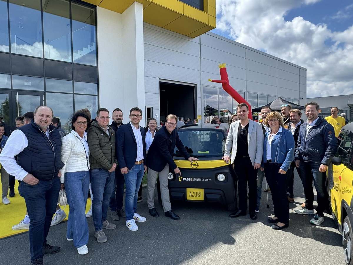 Landtagsabgeordneter Dierl (links vor dem Fahrzeug) zeigt sich begeistert von der Idee der Firmenleitung, den Azubis E-Fahrzeuge zur Verfgung zu stellen.